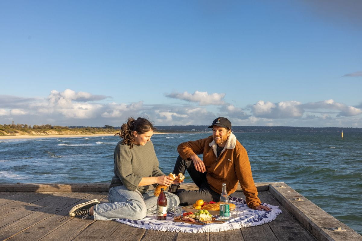 Couple enjoying a sunset picnic at Seaford Pier