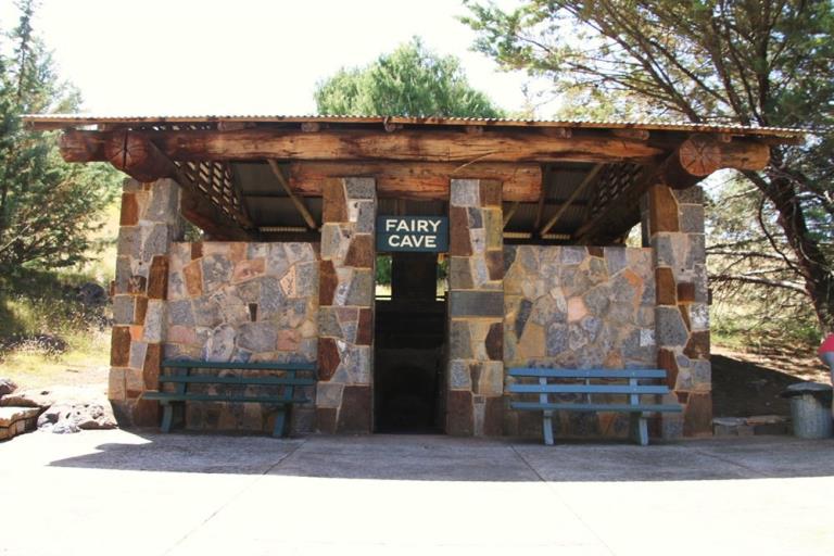 The Fairy Caves entrance before it was damaged in the fires. It has a stone facade and a log timber roof.