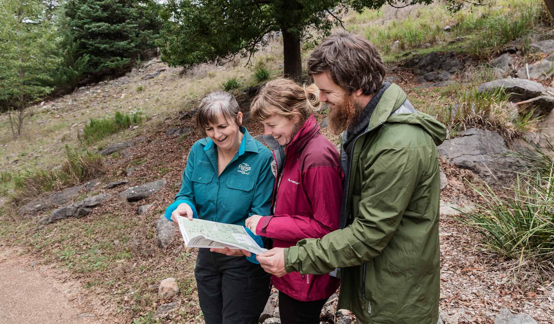 A ranger explains a map to two visitors