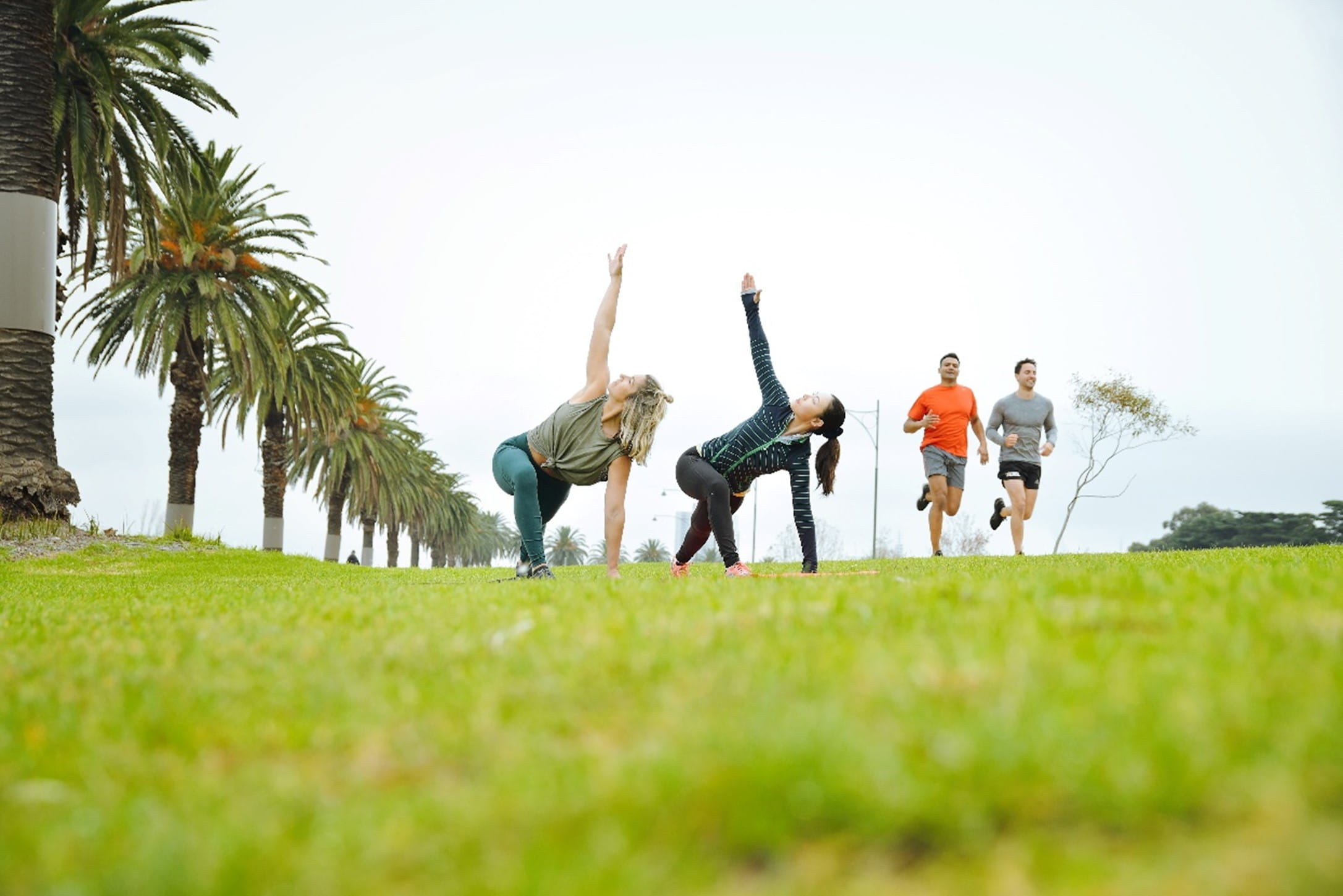 People excercising in parks on green grass