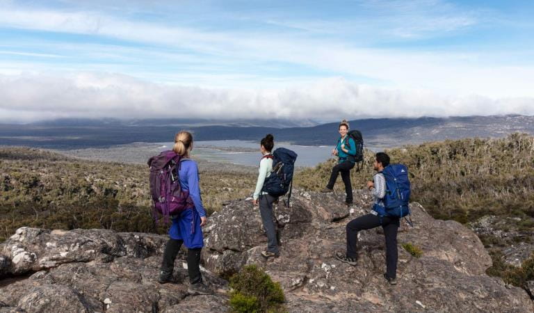 Four hikers standing on rocks looking at the horizon