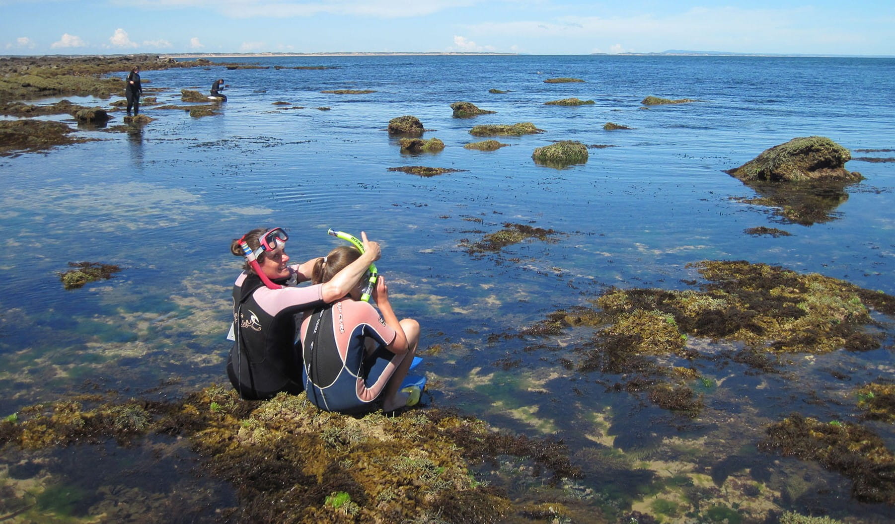 Two snorkellers about to dive into a reef