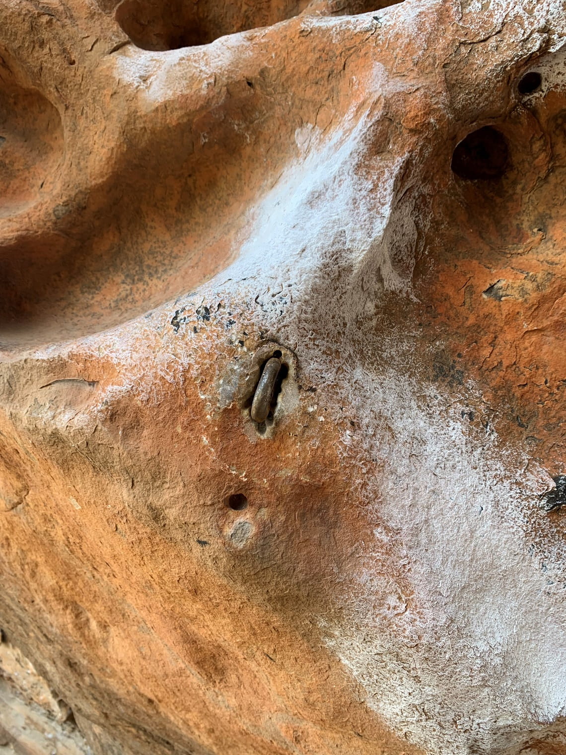 Before rehabilitation, a fixed bolt and climbing chalk graffiti Gariwerd Rock Art shelter Cultivation Creek 19