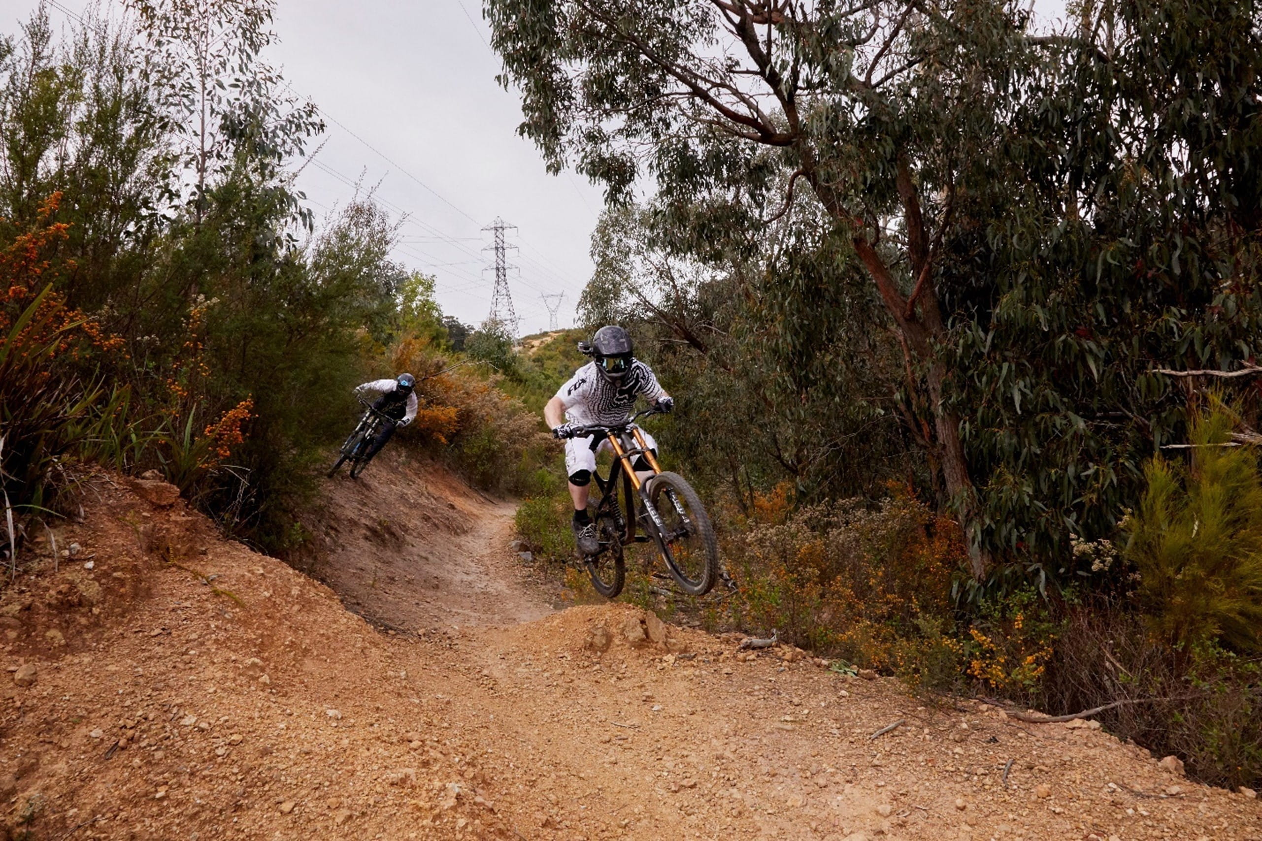 two people are riding their bikes on a dirt path