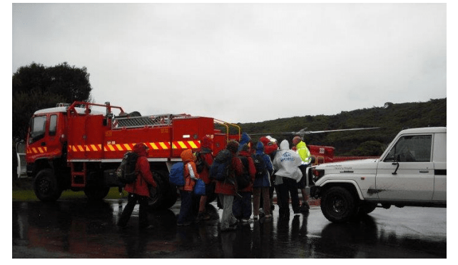 A fire truck and a helicopter with a group of people