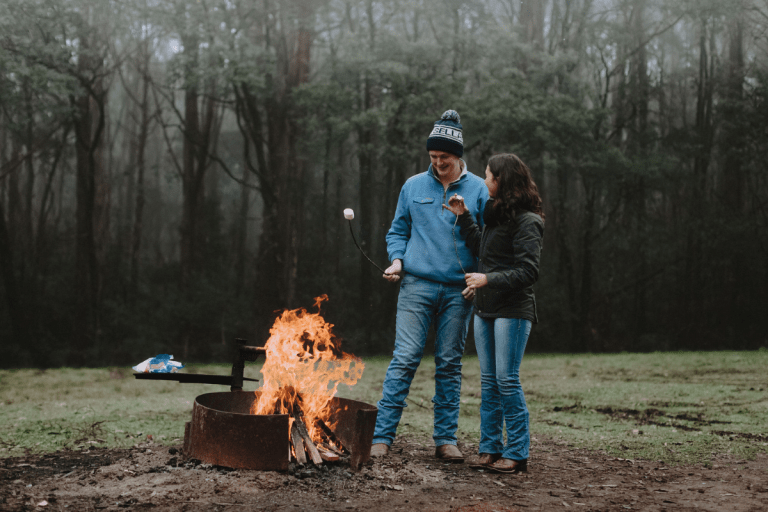 Two people standing around campfire at Days Picnic Area in Macedon Regional Park.