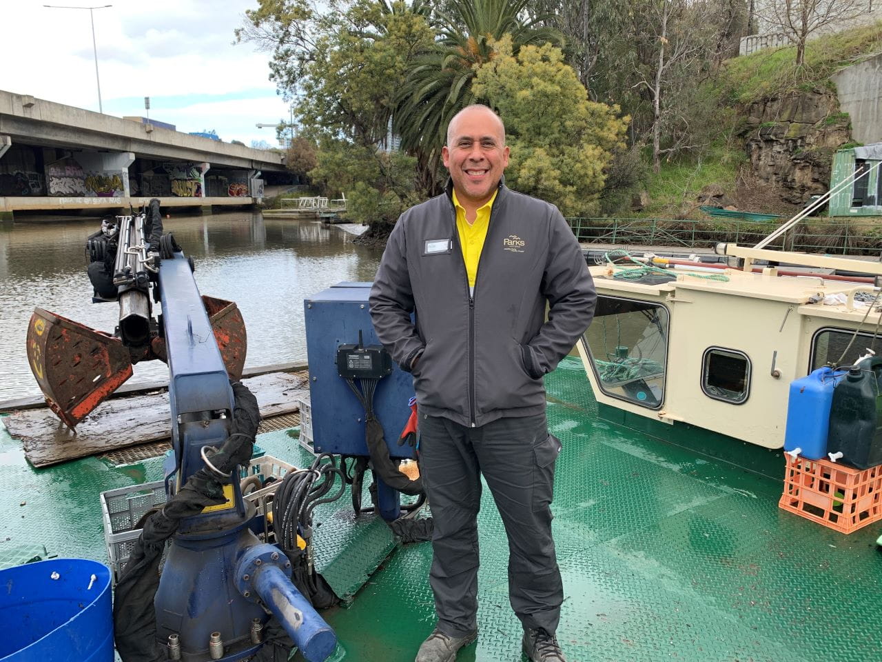 Man standing on a barge with the river in the background