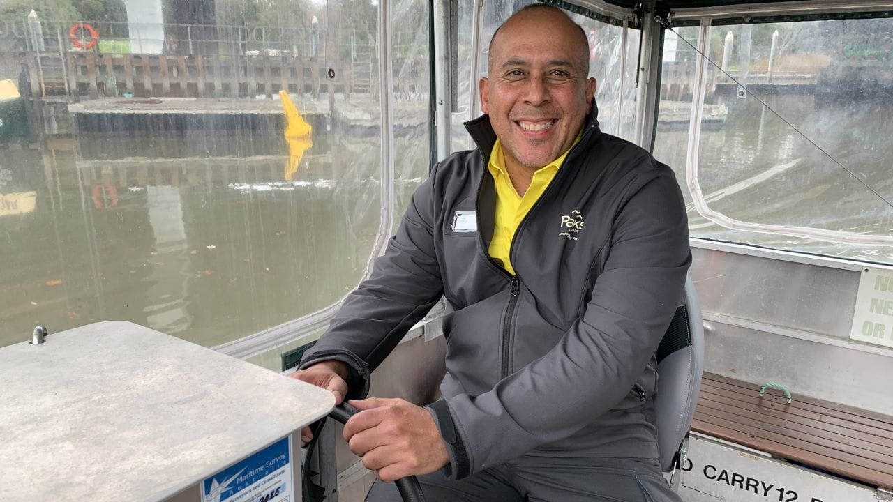 Close up image of Carlos driving a Parks Victoria vehicle, the river in the background