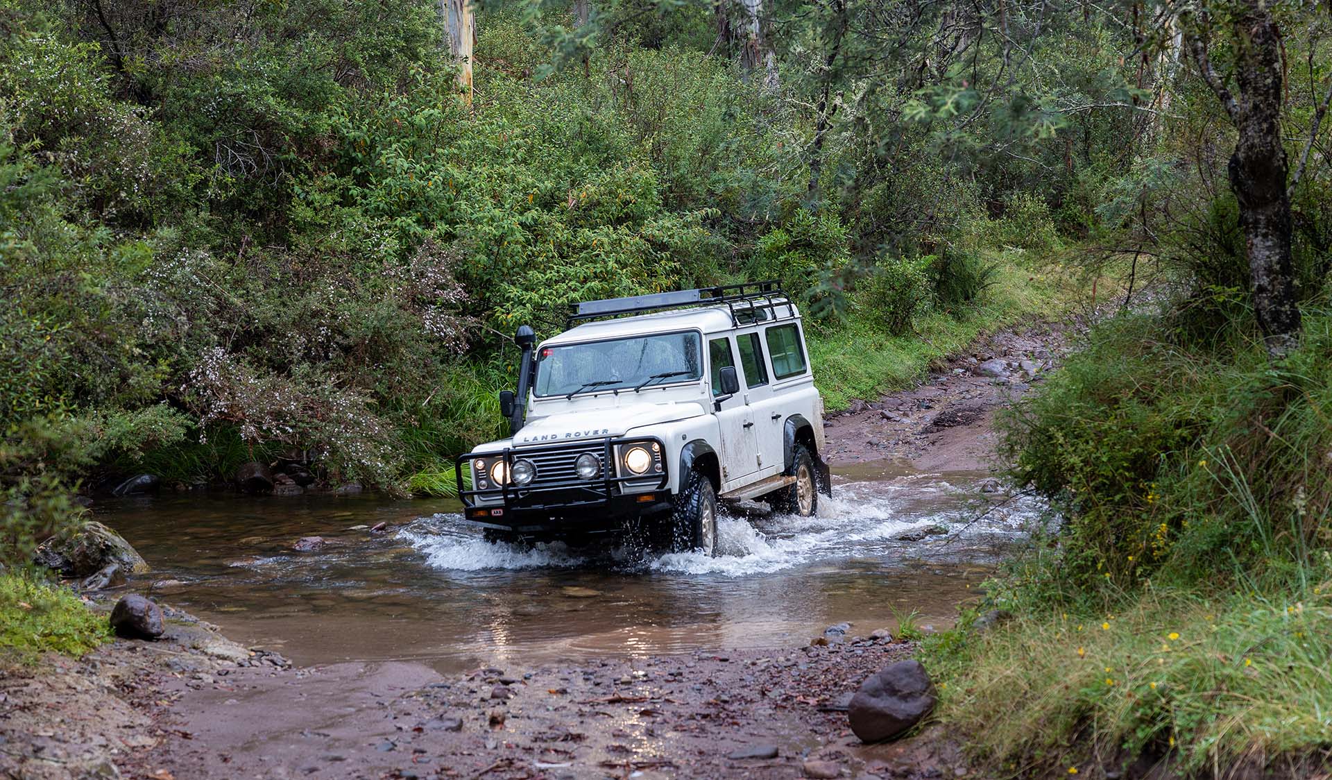 A 4WD drives through a body of water.