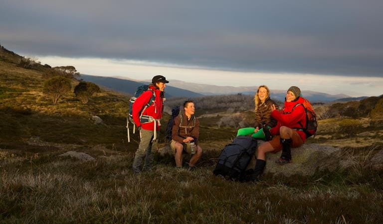 Four friends stop for a later afternoon break on the Falls to Hotham Alpine Crossing.