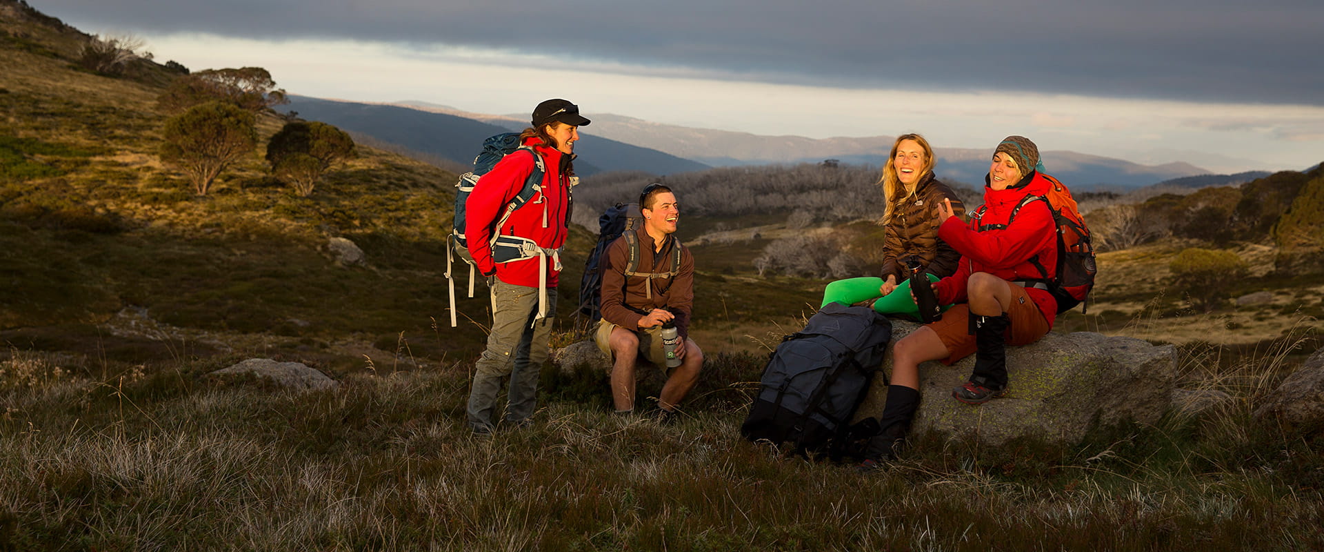 A group of hikers rest and drink water and enjoy the vast alpine landscape