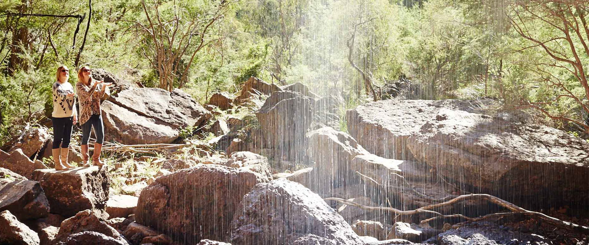 Two women take a photo of the ephemeral Bluff Falls.
