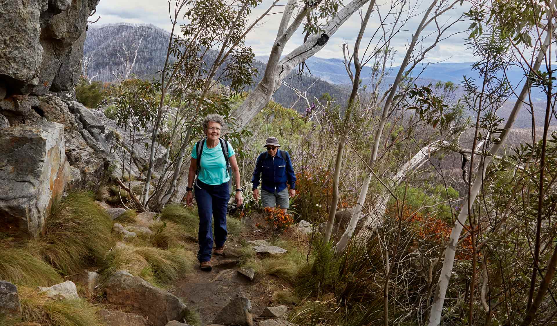 An elderly woman leads her husband along a walking track at Cathedral Range State Park