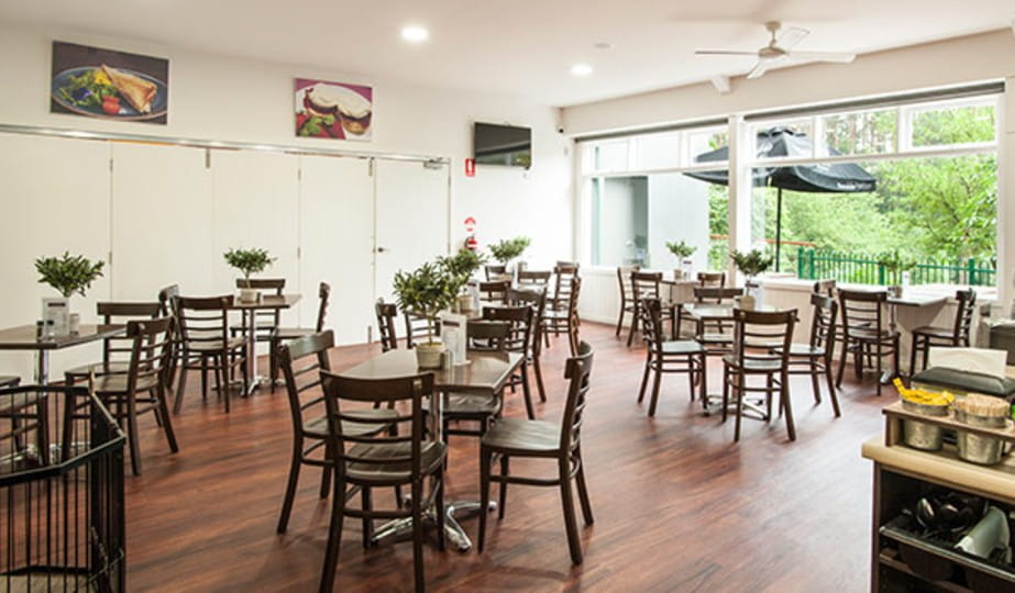 A room full of tables and chairs inside of Garden Cafe Olinda. 