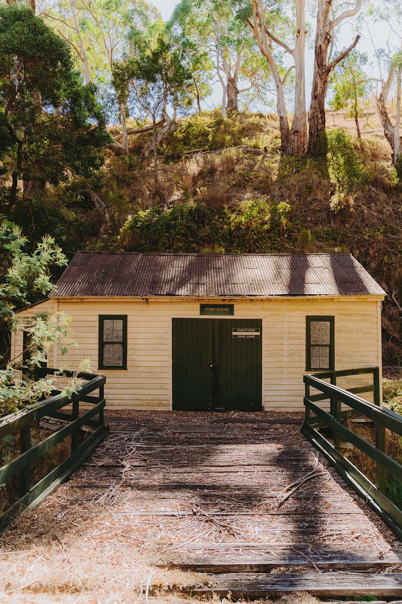 Pump house building at the end of a wooden bridge at Deep Creek Eganstown Streamside Reserve.