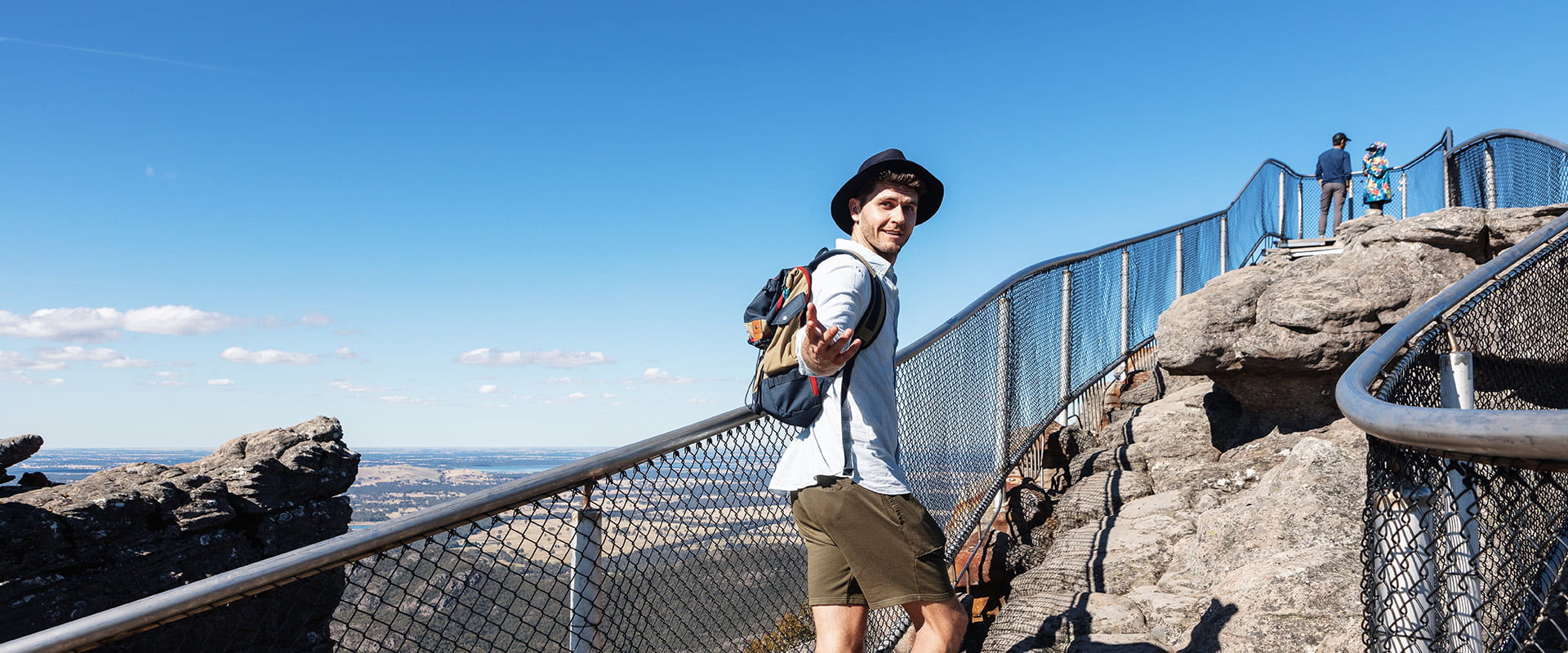 A hiker beckons you to join him as he walks up to the top of the lookout