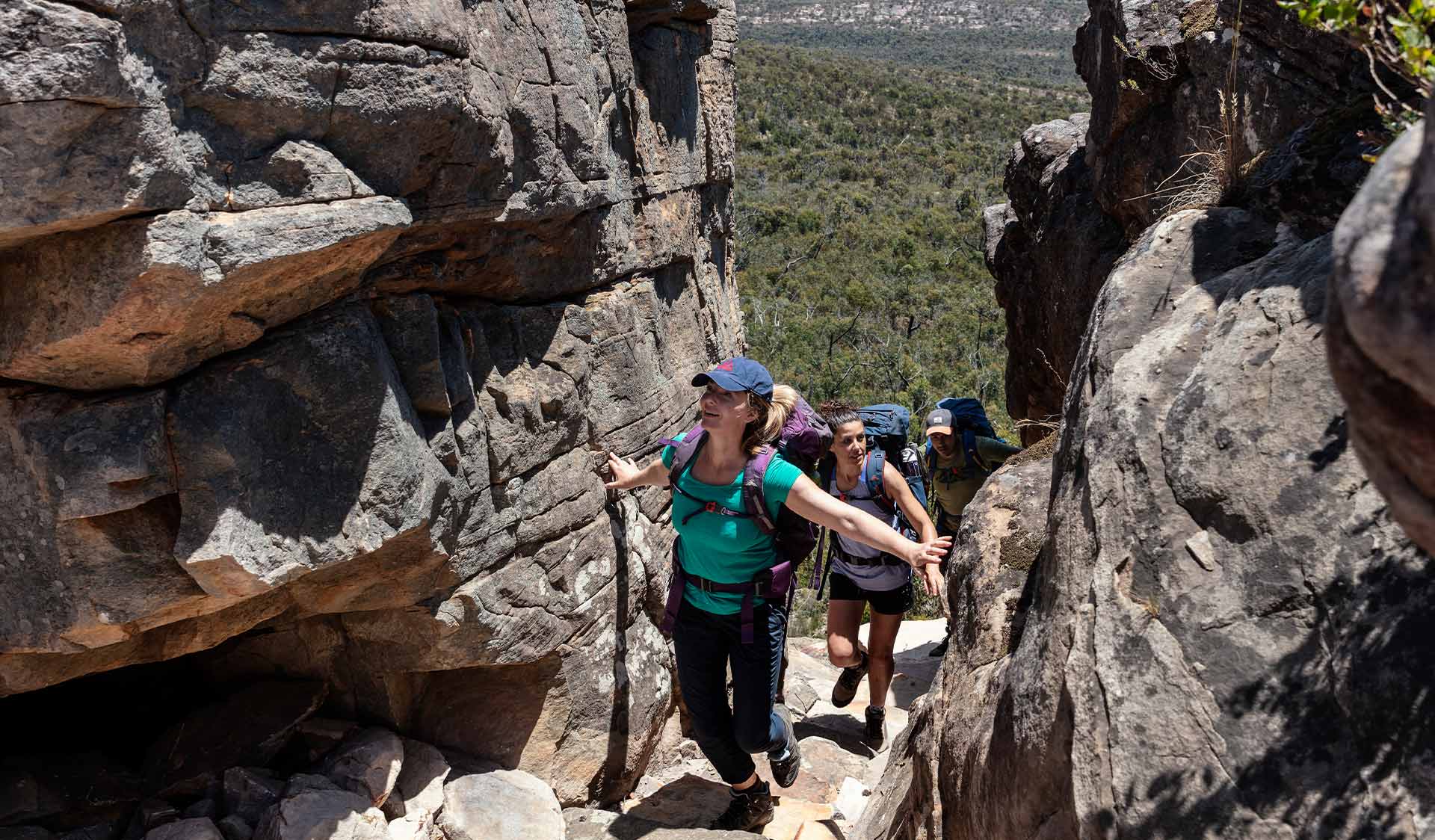 A women hikes through gap on the slopes of Gar / Mount Difficult