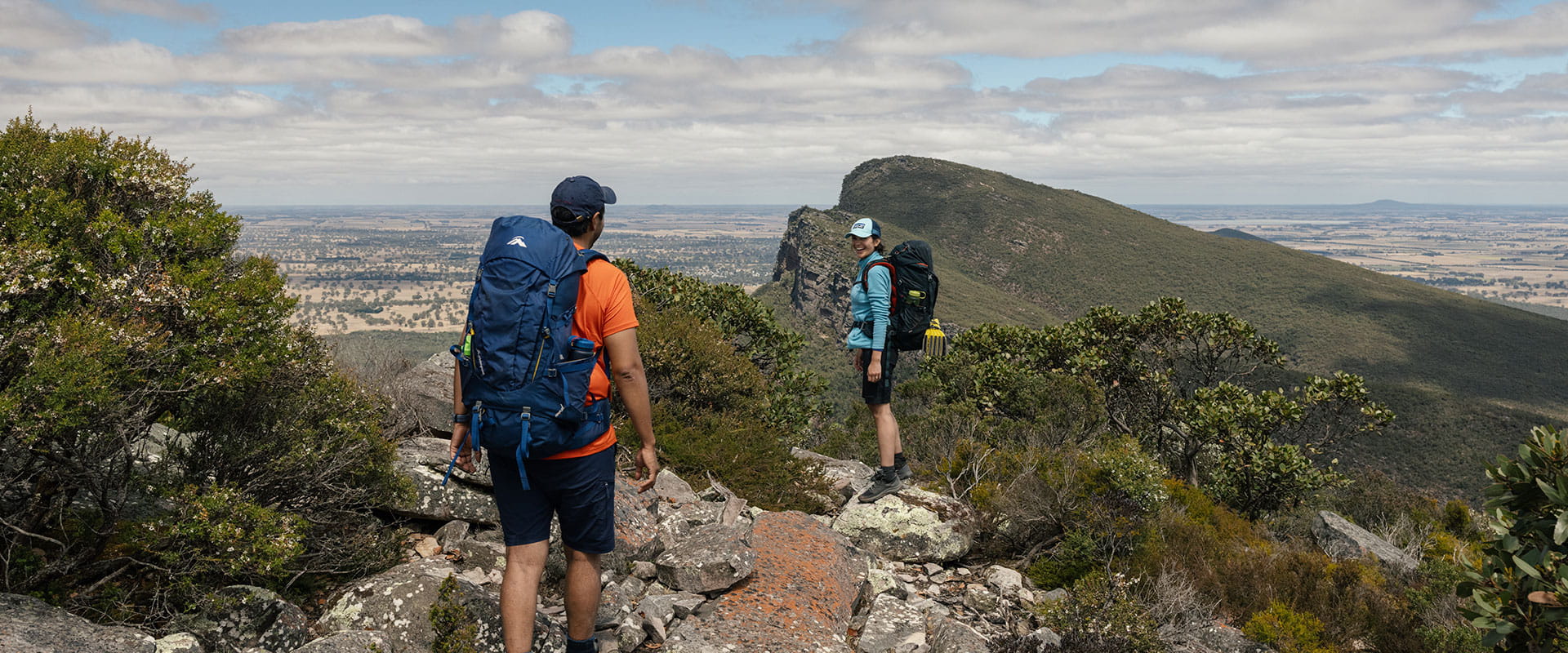 Two hikers arrive at the summit of signal peak taking in big expansive views