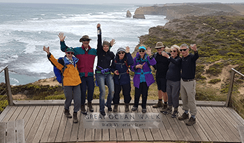 A group of hikers celebrates at the finish line of the Great Ocean Walk
