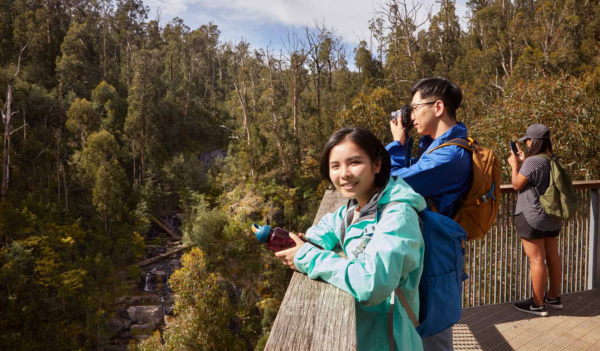 A husband and wife stop to take a photo of Masons Falls from the lookout. 