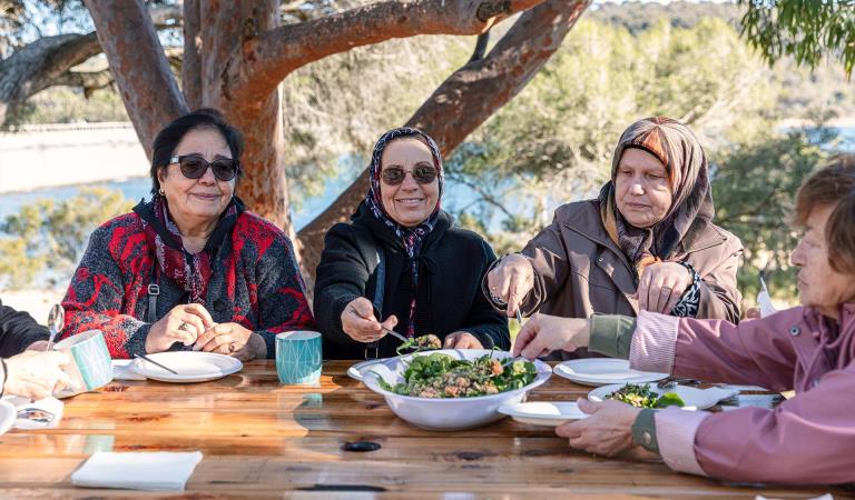 Women from a Turkish community group enjoy a picnic lunch at Lysterfield Park.