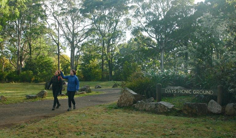 Two women walking along a path, with a Days Picnic Area sign in the foreground.