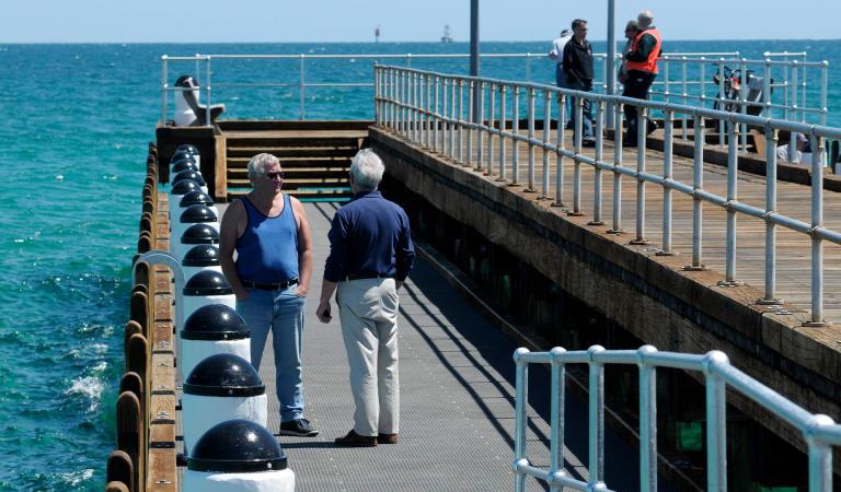 Two men chat on the Rosebud Pier.