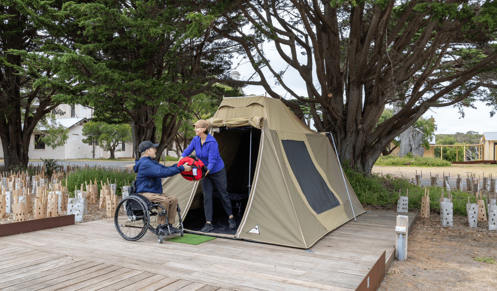 Two people at the entrance of a wheelchair accessible tent.