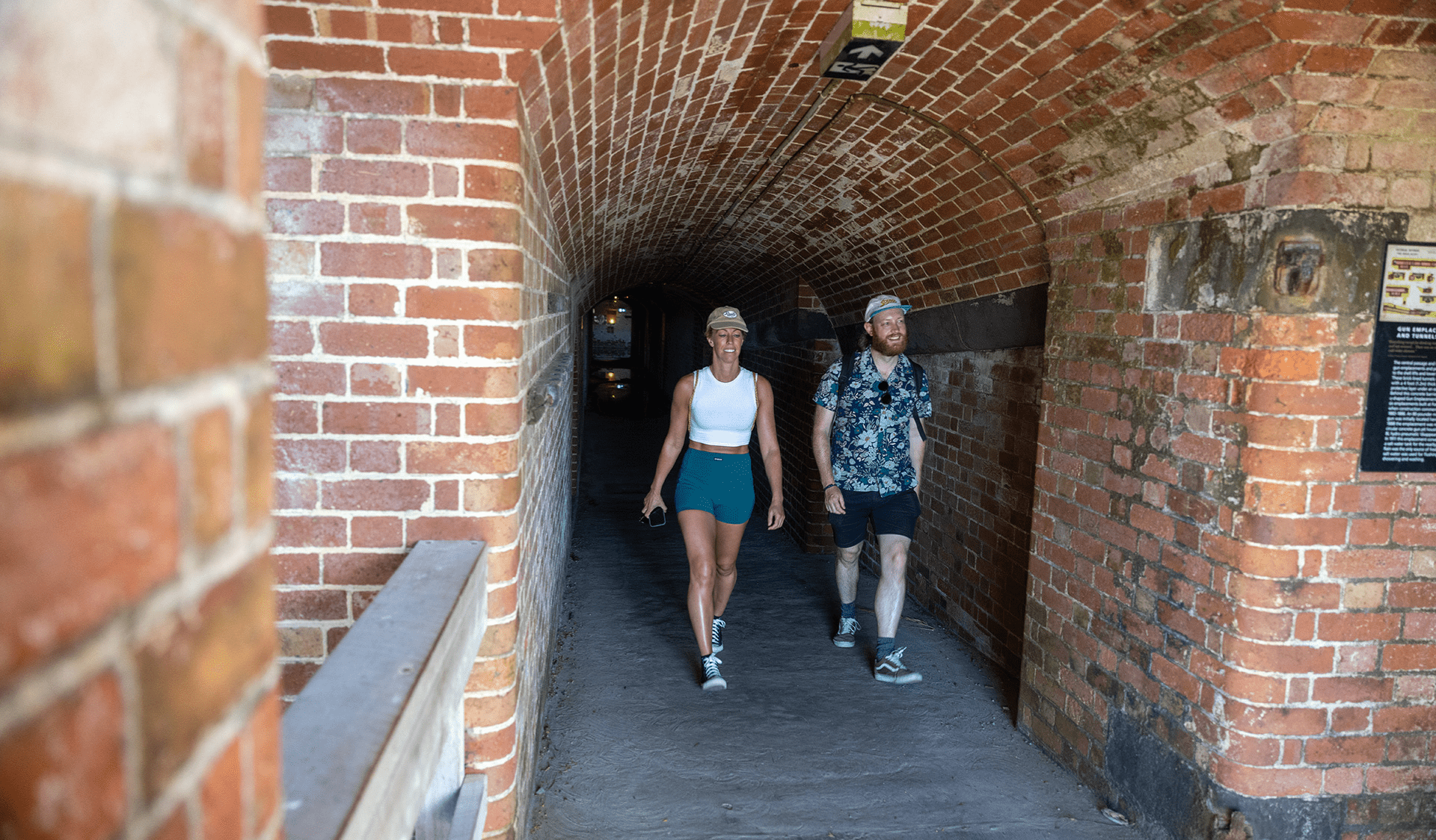 Two people walking through an underground fort.