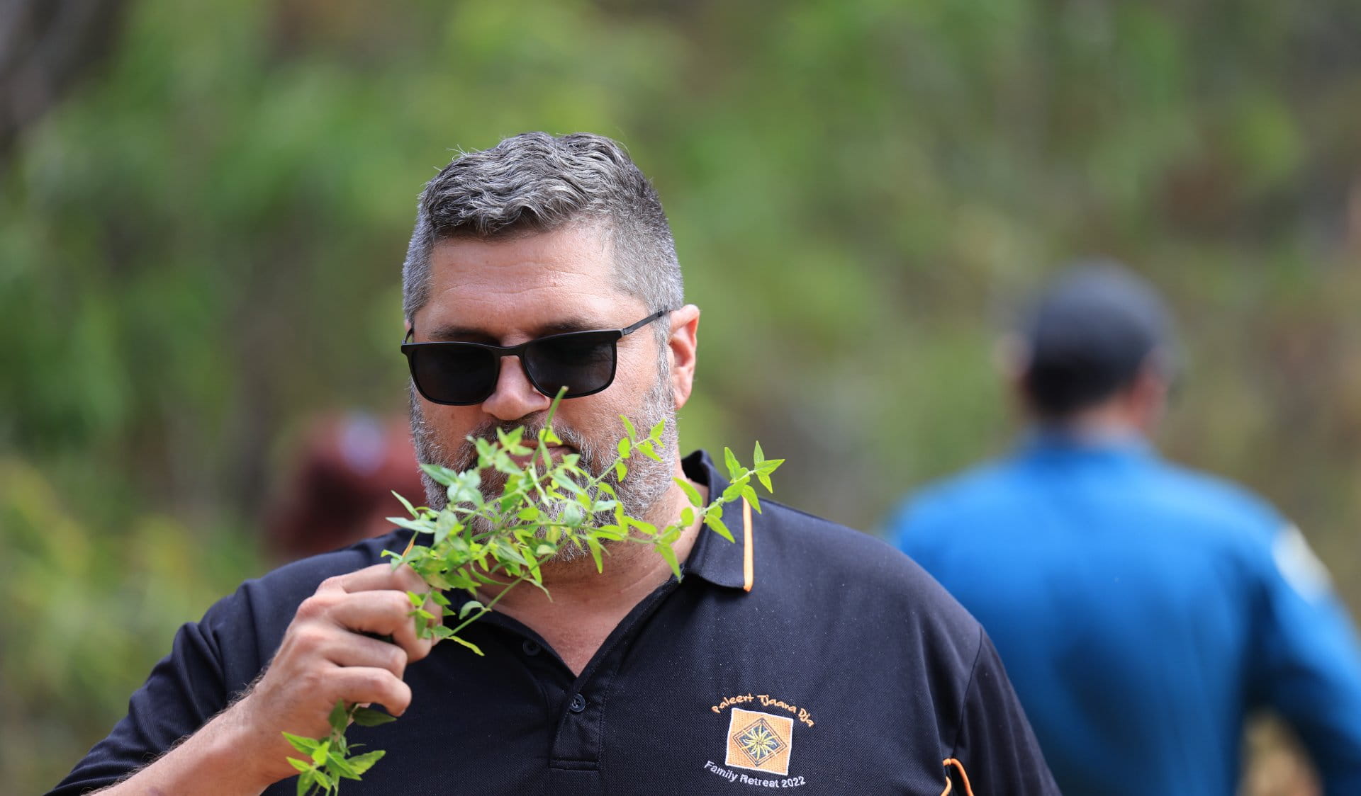 A man is smelling native mint in the ‘Taste’ space in the Sensory Garden.