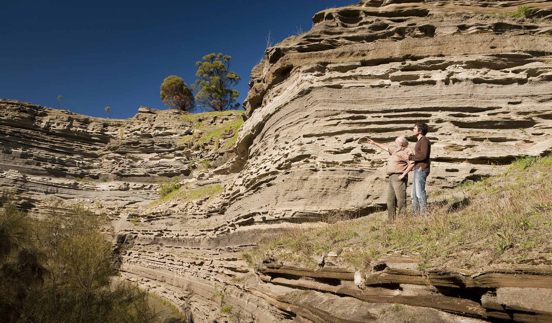 Two men discuss the formation of the crater at Tower Hill.