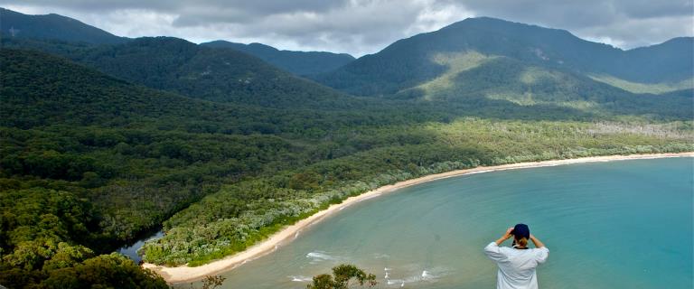 A person looks out at the view of the water and landscape of Sealers Bay at Wilsons Promontory National Park.