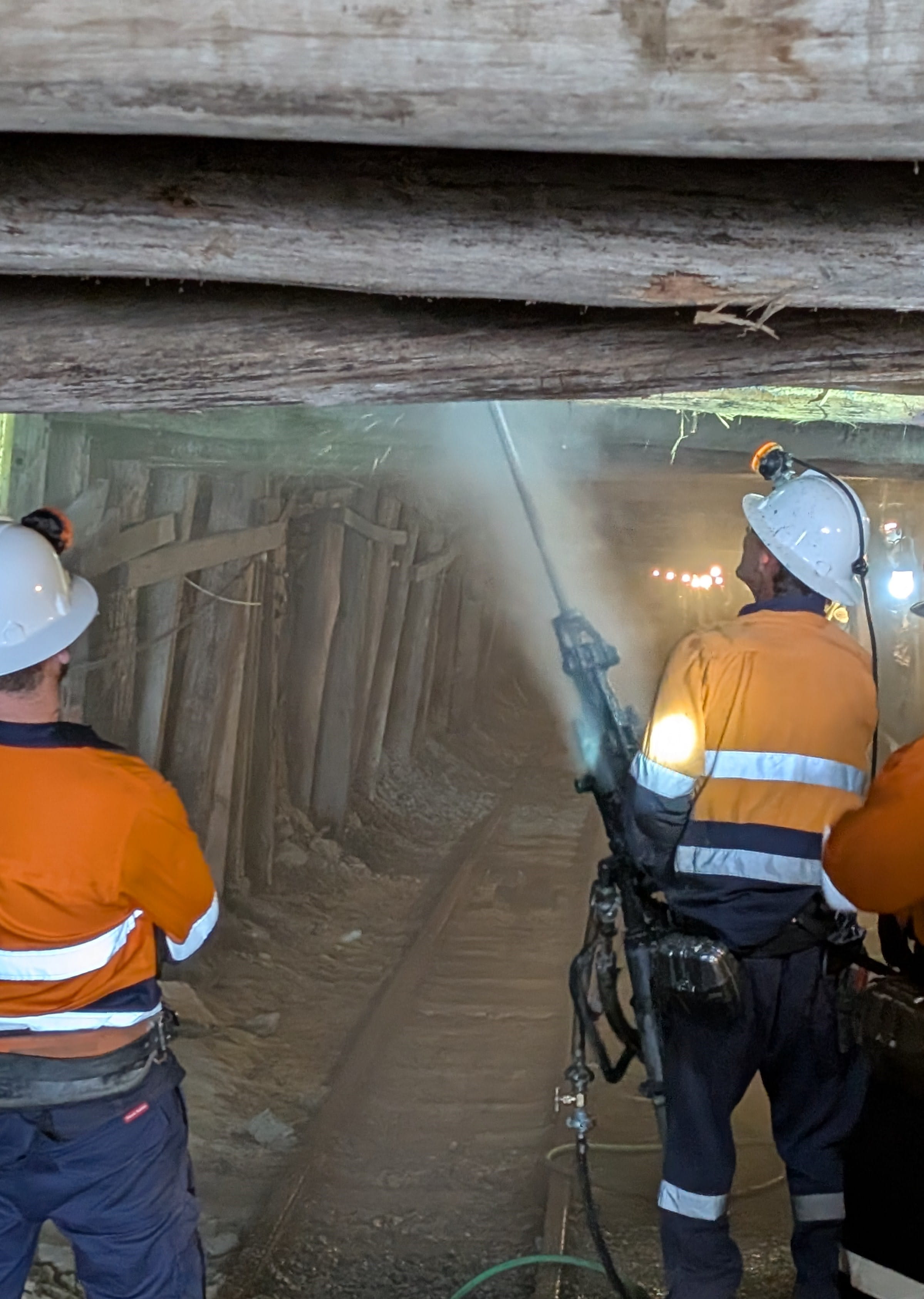 Three workers wearing hi-vis walking through the State Coal Mine. 