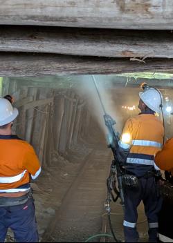 Three workers wearing hi-vis walking through the State Coal Mine.