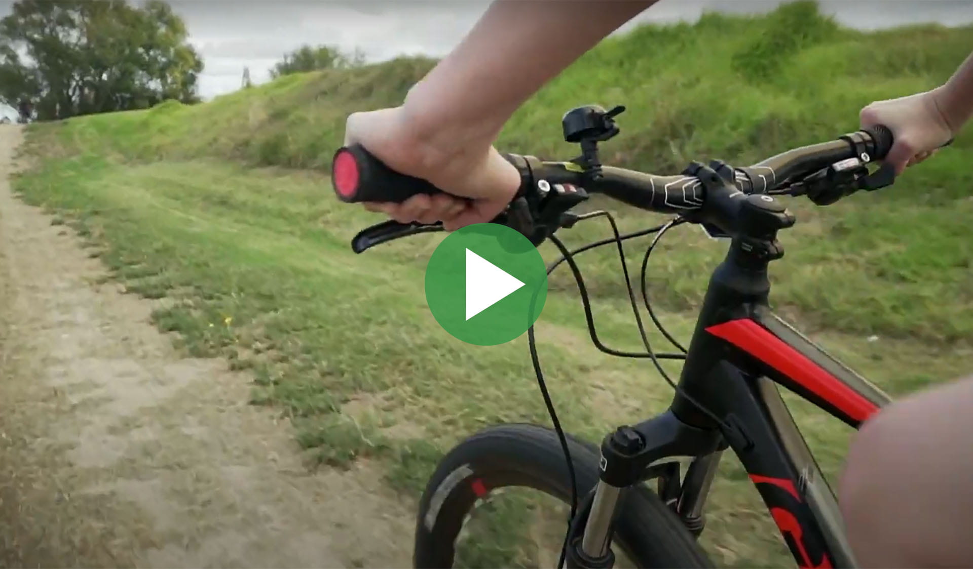 Still image from video of a person on a bike with play icon overlay