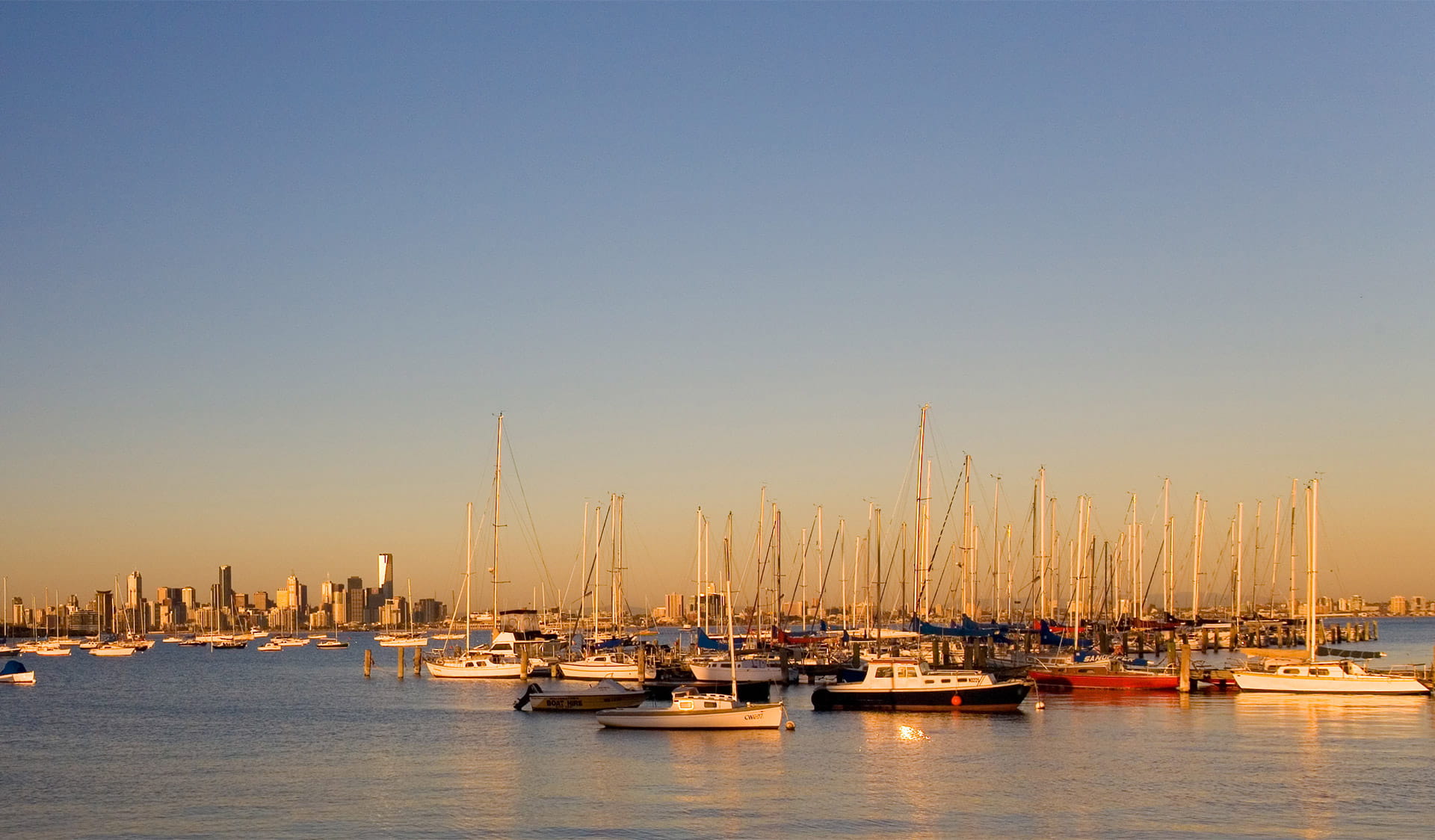 boats in the water and city skyline at sunset
